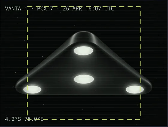 A sighting photograph of a dark triangular craft with a bright light at each corner and one in the centre.